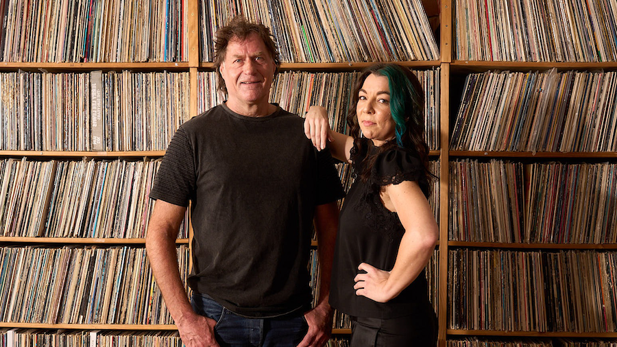 Robert Taylor & Georgia Cubbon pose in front of vinyl record collection