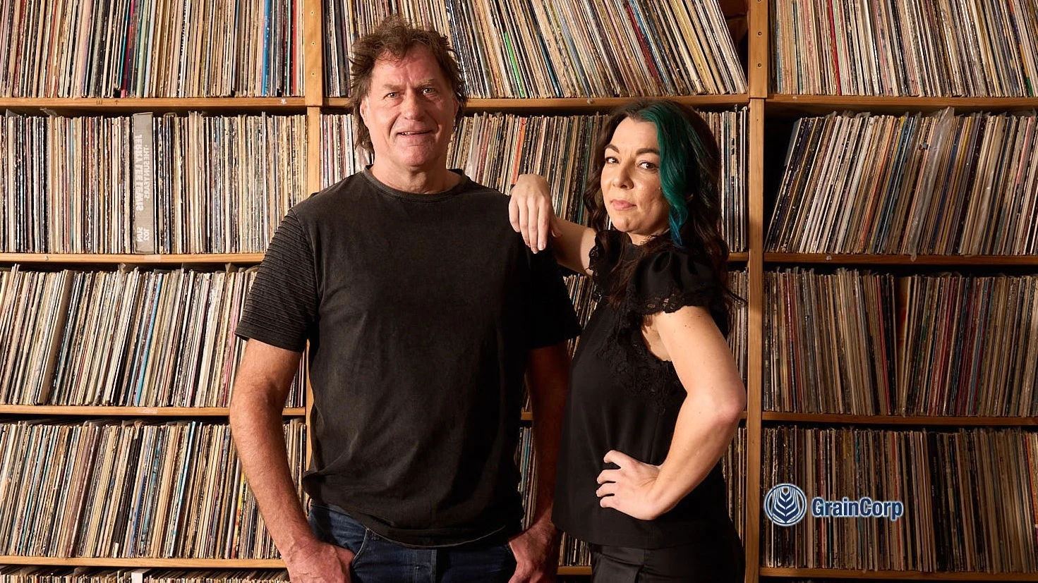 Robert Taylor & Georgia Cubbon pose in front of vinyl record collection