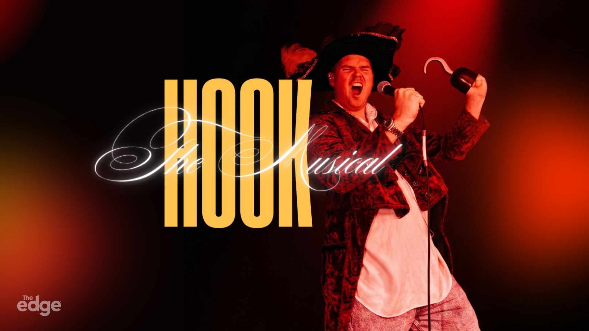 A man dressed as a pirate, with a hook hand and microphone, sings on a red-lit stage with the text "HOOK The Musical" and "The edge" logo.