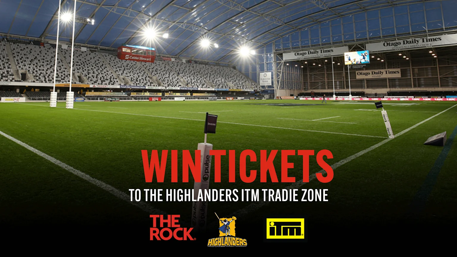 Brightly lit indoor rugby stadium with green artificial turf, white goal posts, and empty black and white seating. Advertising banners for Opulse, Southland Loan & Finance, Calder Stewart, Otago Daily Times, KFC, and more surround the field. A distant person walks on the field. Red and white overlay text promotes ticket giveaway for Highlanders ITM Tradie Zone, along with logos of The Rock, Highlanders, and ITM.