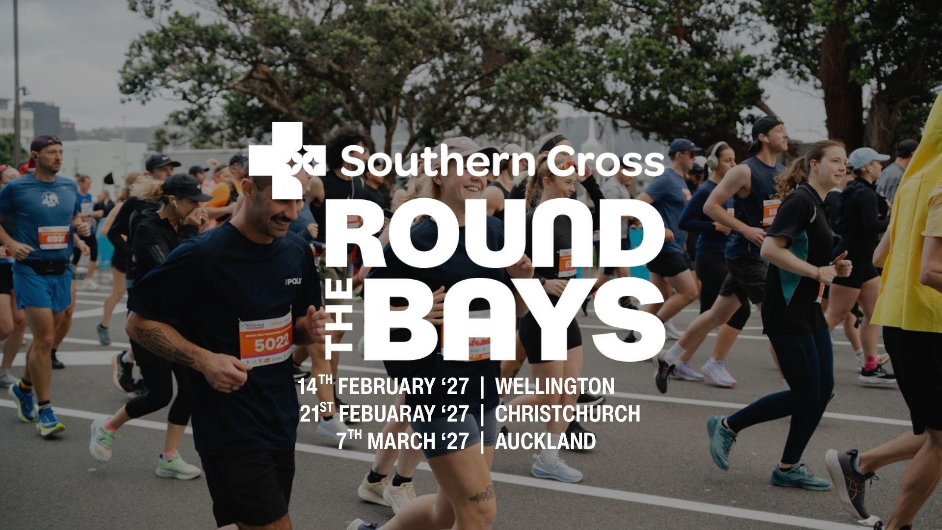 A large group of runners participates in the Southern Cross Round The Bays event, with the event title, dates, and locations (Wellington, Christchurch, Auckland in 2027) clearly overlaid on the image.