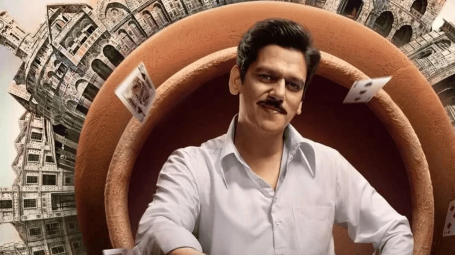 A smiling man with a mustache wears a white shirt, framed by a large brown ring, with playing cards floating around him and intricate city structures in the background.