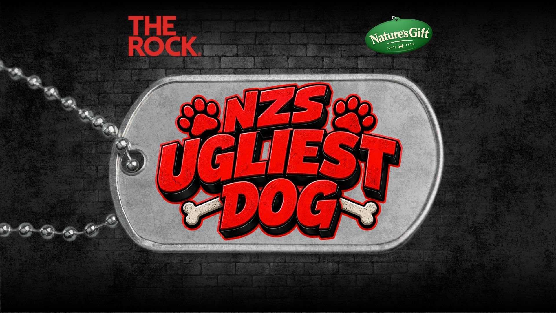 A silver dog tag with "NZS UGLIEST DOG" in red text, accented by paw prints and bones, lies against a dark brick wall, with "THE ROCK" and "Nature's Gift" logos also visible.