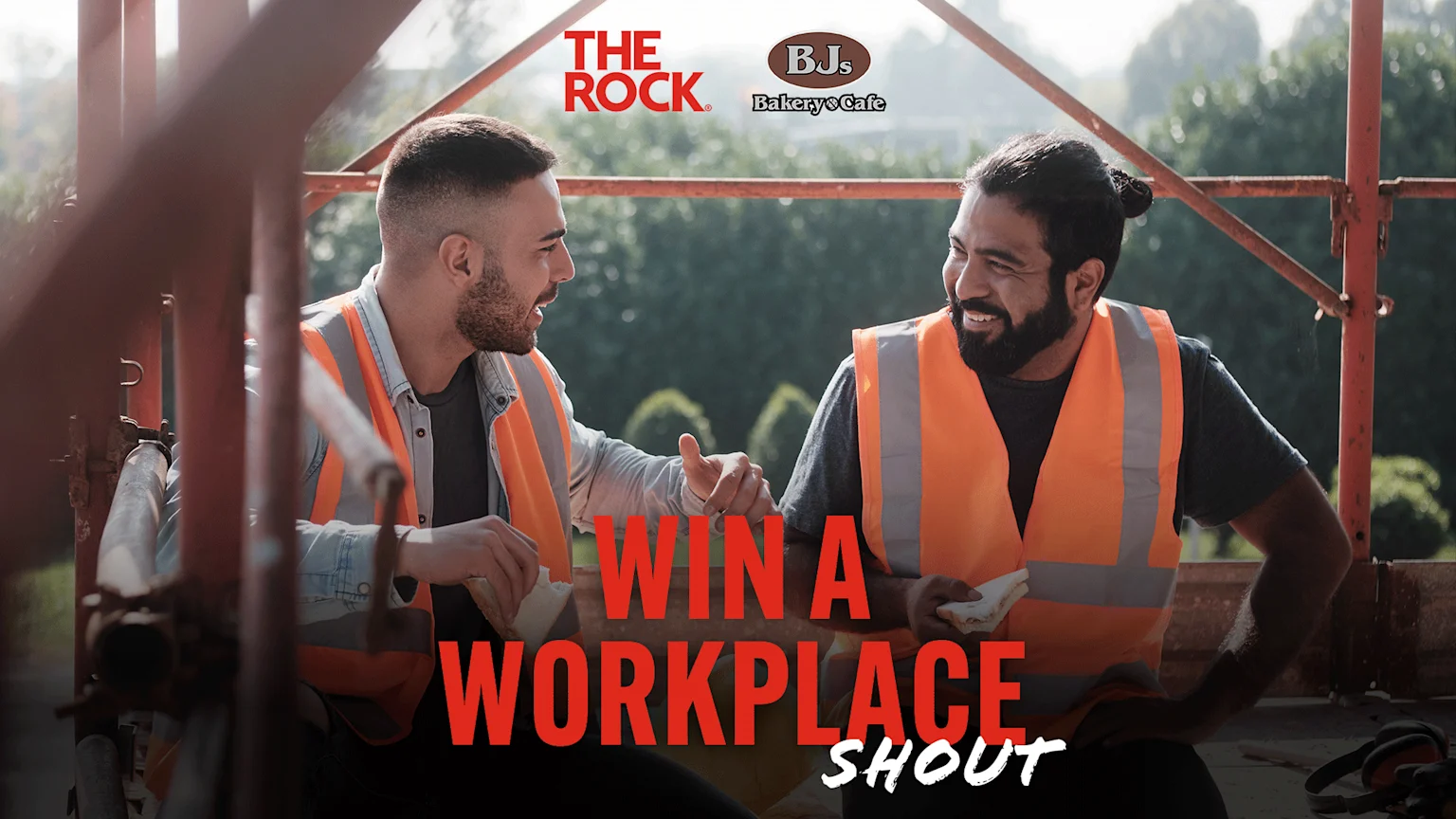 Two smiling construction workers in high-vis vests share sandwiches on scaffolding, with sponsor logos and text "WIN A WORKPLACE SHOUT".