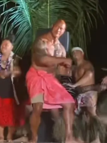 Dwayne The Rock on stage surrounded by family dancing a Samoan culture sacred dance, the Taualuga.