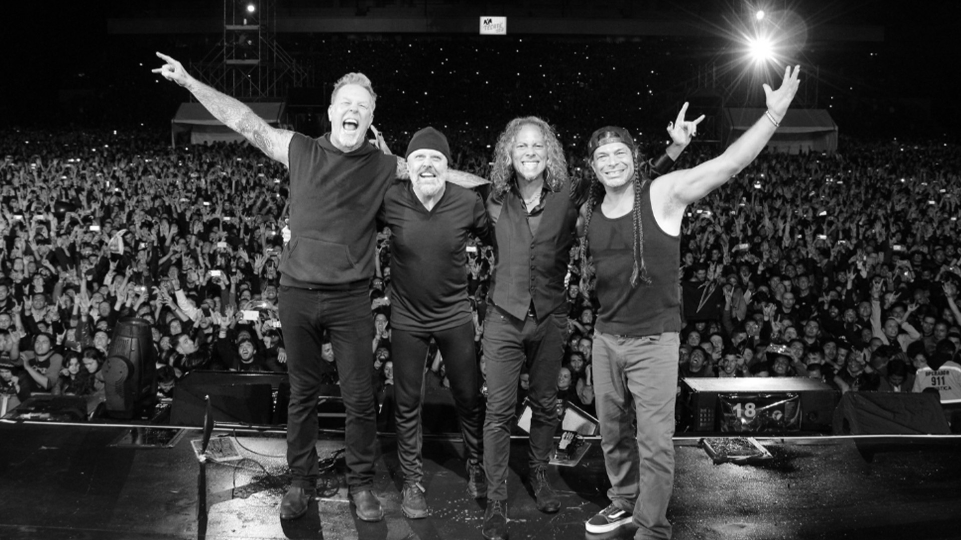 All four Metallica members standing on-stage