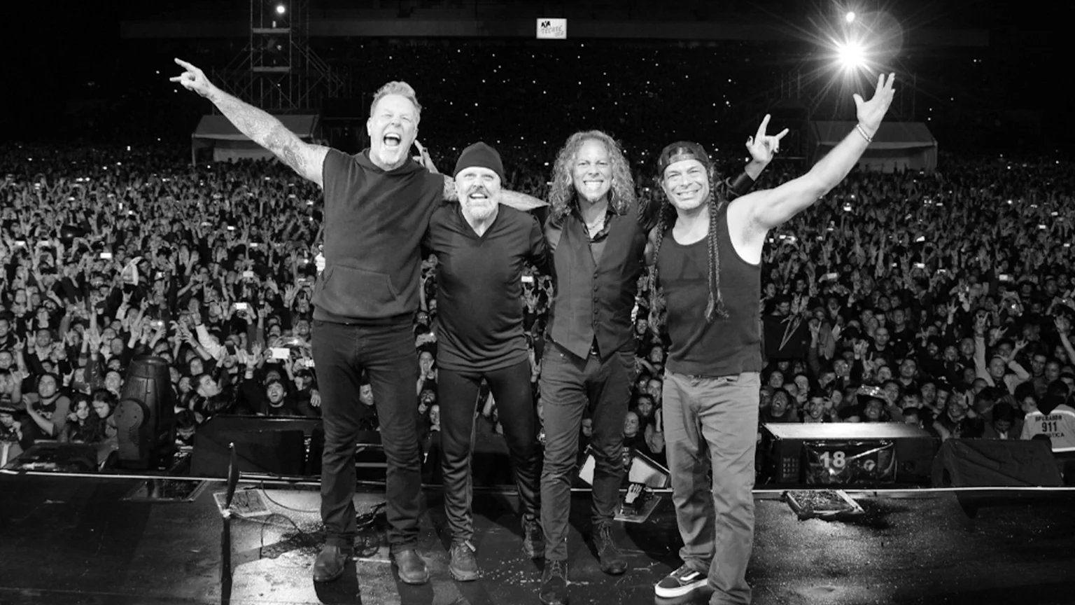 All four Metallica members standing on-stage