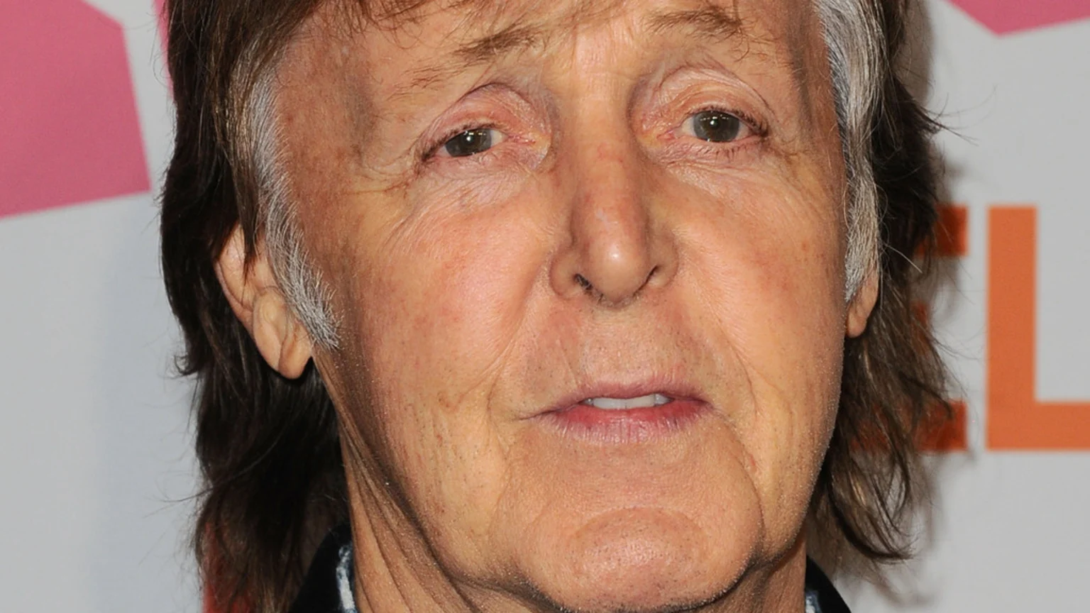 Close-up of Paul McCartney's face, showing his brown and graying hair, and his eyes looking forward.