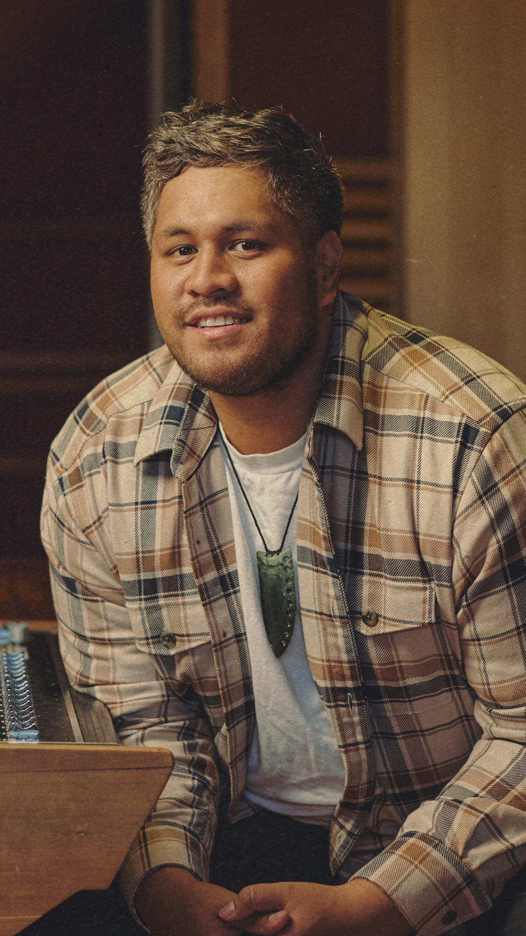 Storme is sitting next to a music production mixer.