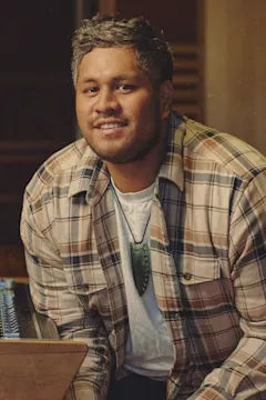 Storme is sitting next to a music production mixer.