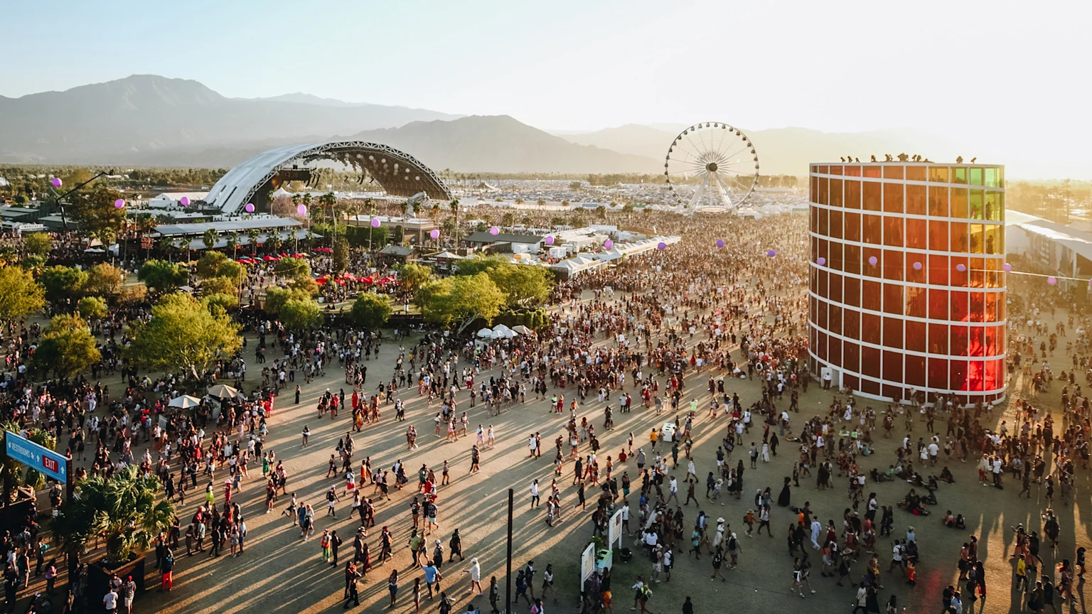 Coachella festival with crowds and mountains.