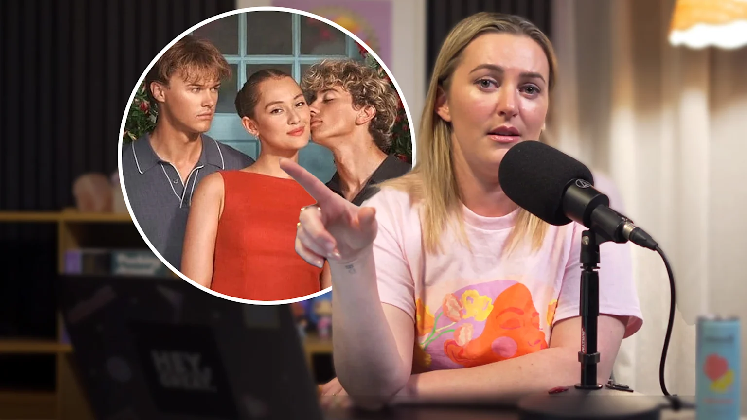 Sharyn Casey speaking into a microphone in front of a photo of the cast of The Summer I Turned Pretty