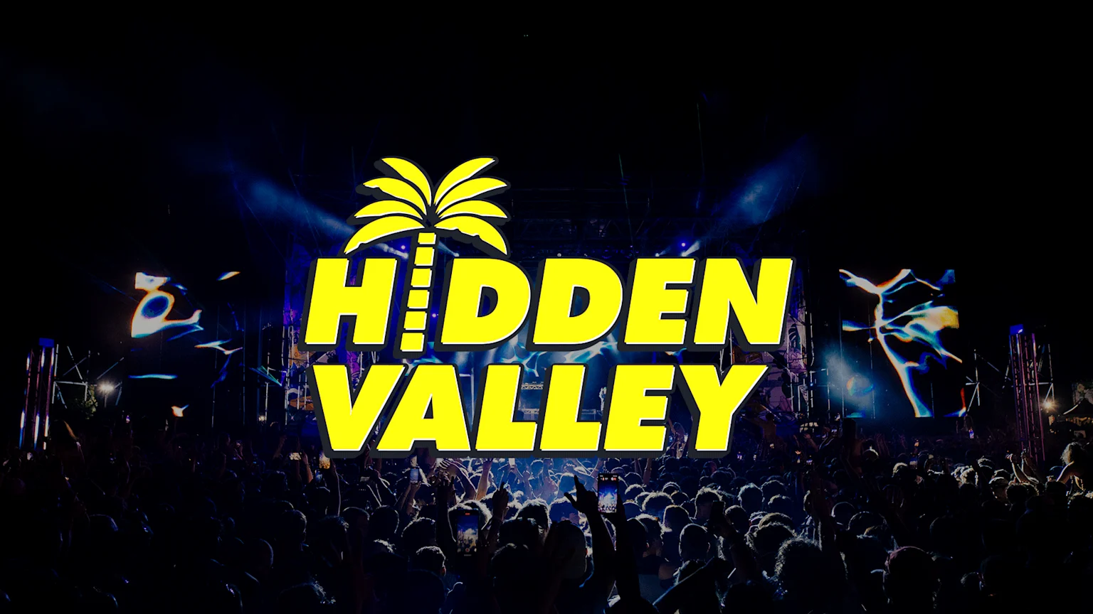 A large crowd attends a night concert with a brightly lit stage in the background, featuring a prominent yellow "HIDDEN VALLEY" logo with a palm tree icon.