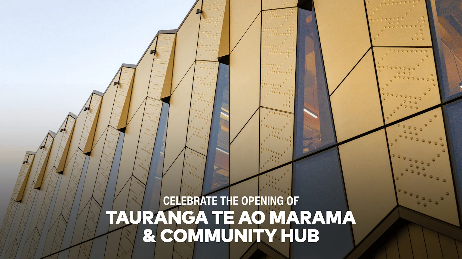 A modern building with a geometric golden facade featuring perforated patterns and glass sections, under a clear sky, with the text overlay "CELEBRATE THE OPENING OF TAURANGA TE AO MARAMA & COMMUNITY HUB".