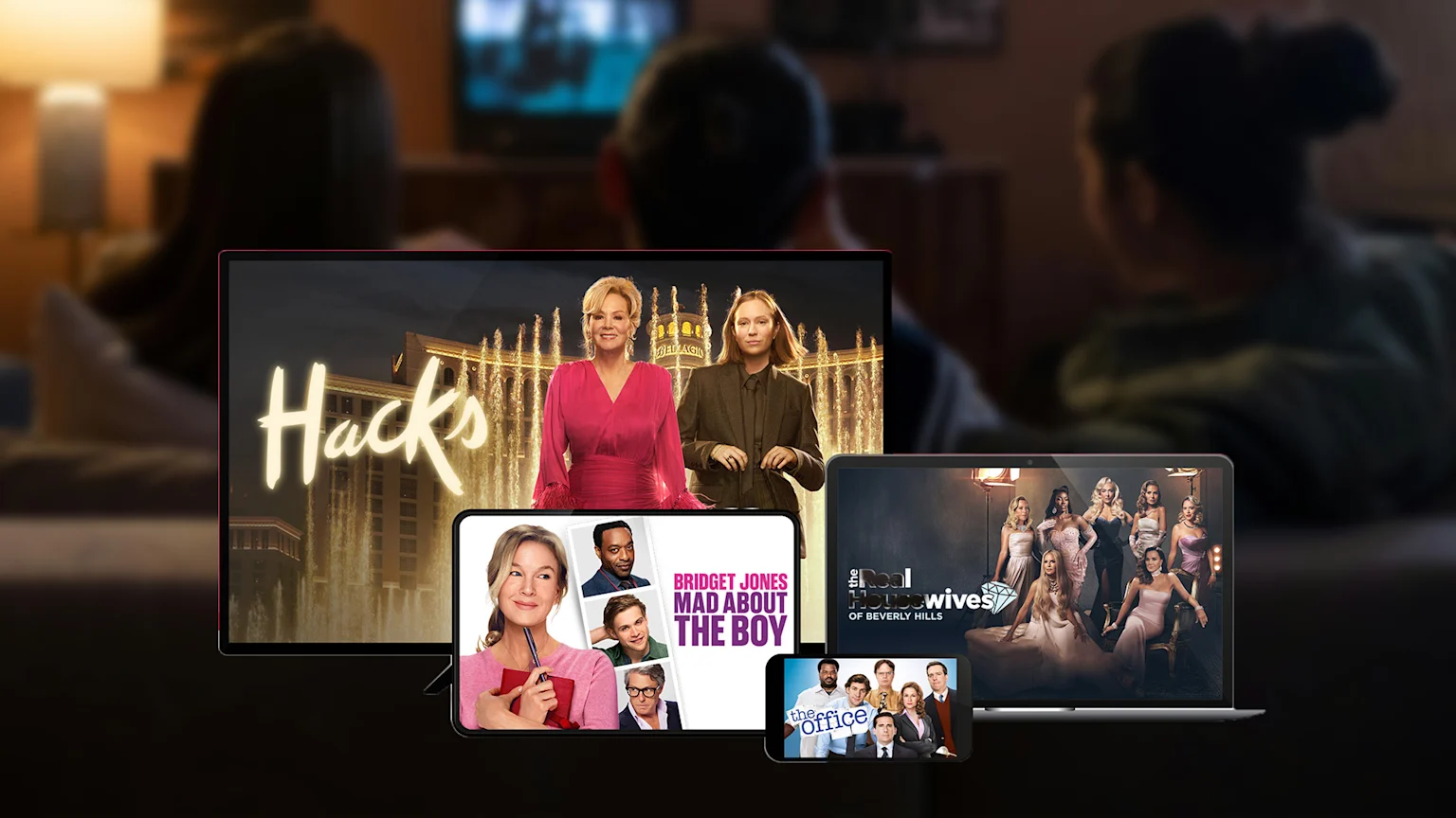 Multiple screens display "Hacks," "Bridget Jones: Mad About The Boy," "The Real Housewives of Beverly Hills," and "The Office," set against a blurred background of people watching TV.