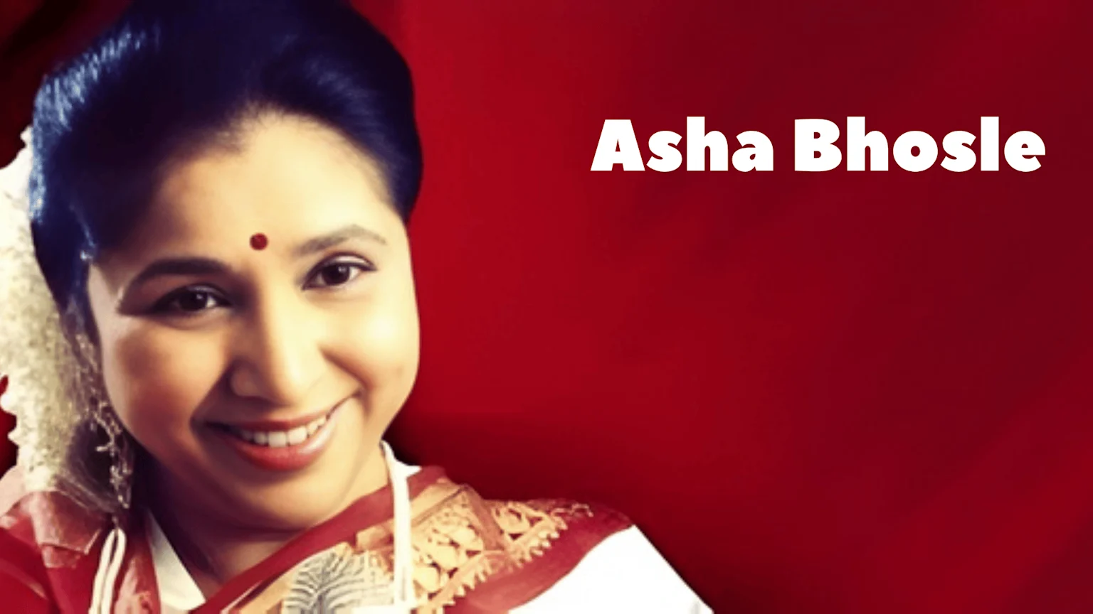 A smiling Asha Bhosle, adorned with a red bindi and traditional Indian attire, is set against a red background with her name "Asha Bhosle" written in white text.