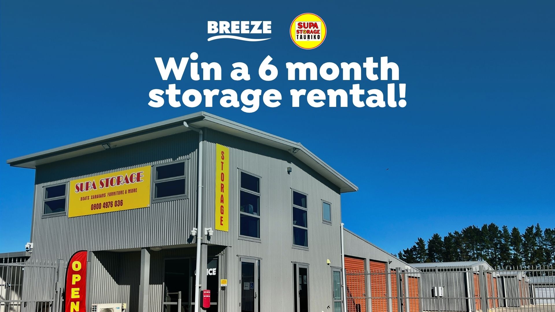 A Supa Storage facility with grey buildings, orange storage units, and yellow signage under a blue sky, overlaid with a 'Win a 6 month storage rental!' promotion.