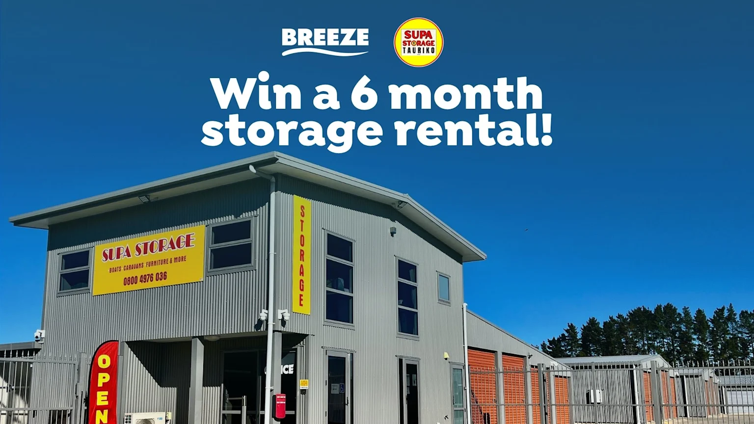 A Supa Storage facility with grey buildings, orange storage units, and yellow signage under a blue sky, overlaid with a 'Win a 6 month storage rental!' promotion.
