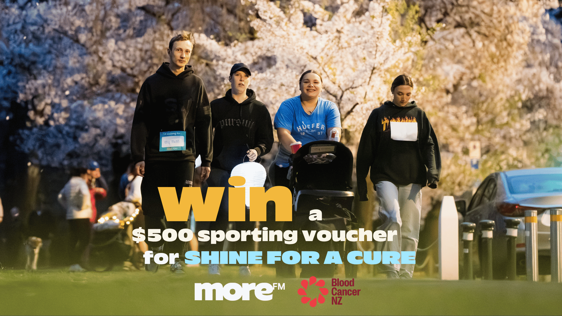 A diverse group walks outdoors at dusk, with text overlays promoting a 'Shine For A Cure' event supported by More FM and Blood Cancer NZ, offering a $500 sporting voucher.