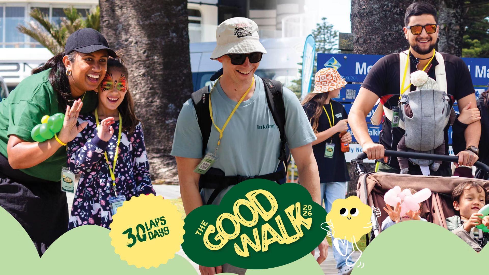Happy participants of The Good Walk 2026, including adults and children with face paint and in strollers, walk outdoors on a sunny day.