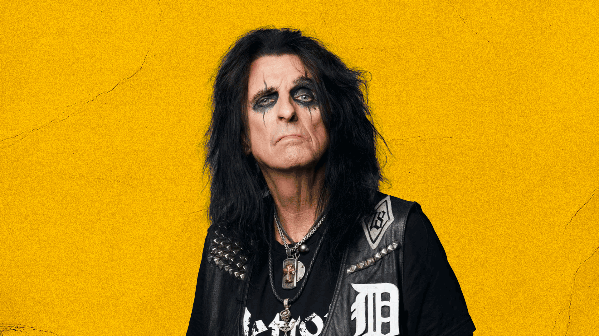 Alice Cooper with gothic makeup in front of yellow wall
