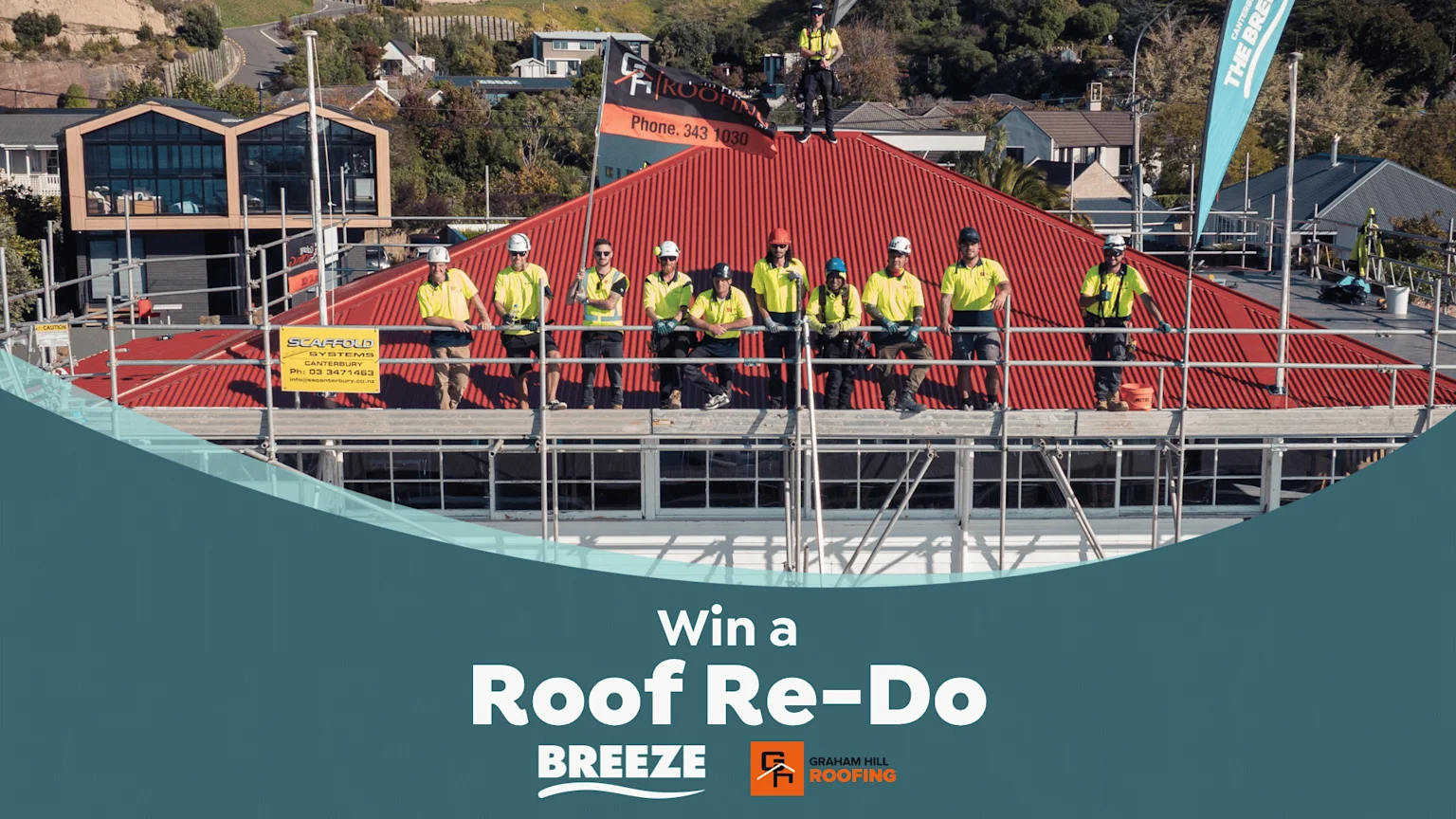 A team of roofers in yellow shirts and hard hats stand on scaffolding and a red corrugated roof, with "Graham Hill Roofing" branding and a "Win a Roof Re-Do" promotion.