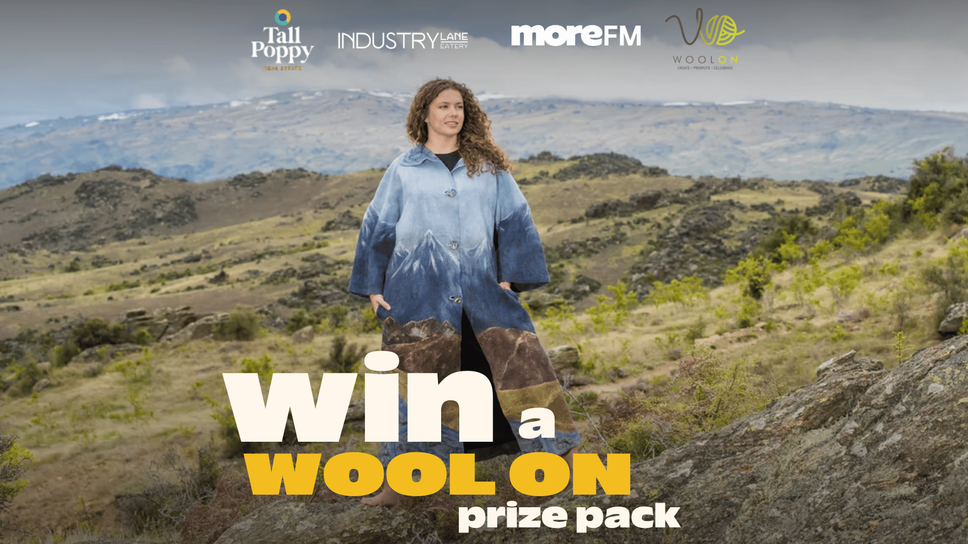 A woman in a blue mountain-themed coat stands on a rocky hill under logos for Tall Poppy, Industry Lane Eatery, moreFM, and WoolOn, with text reading "win a WOOL ON prize pack".