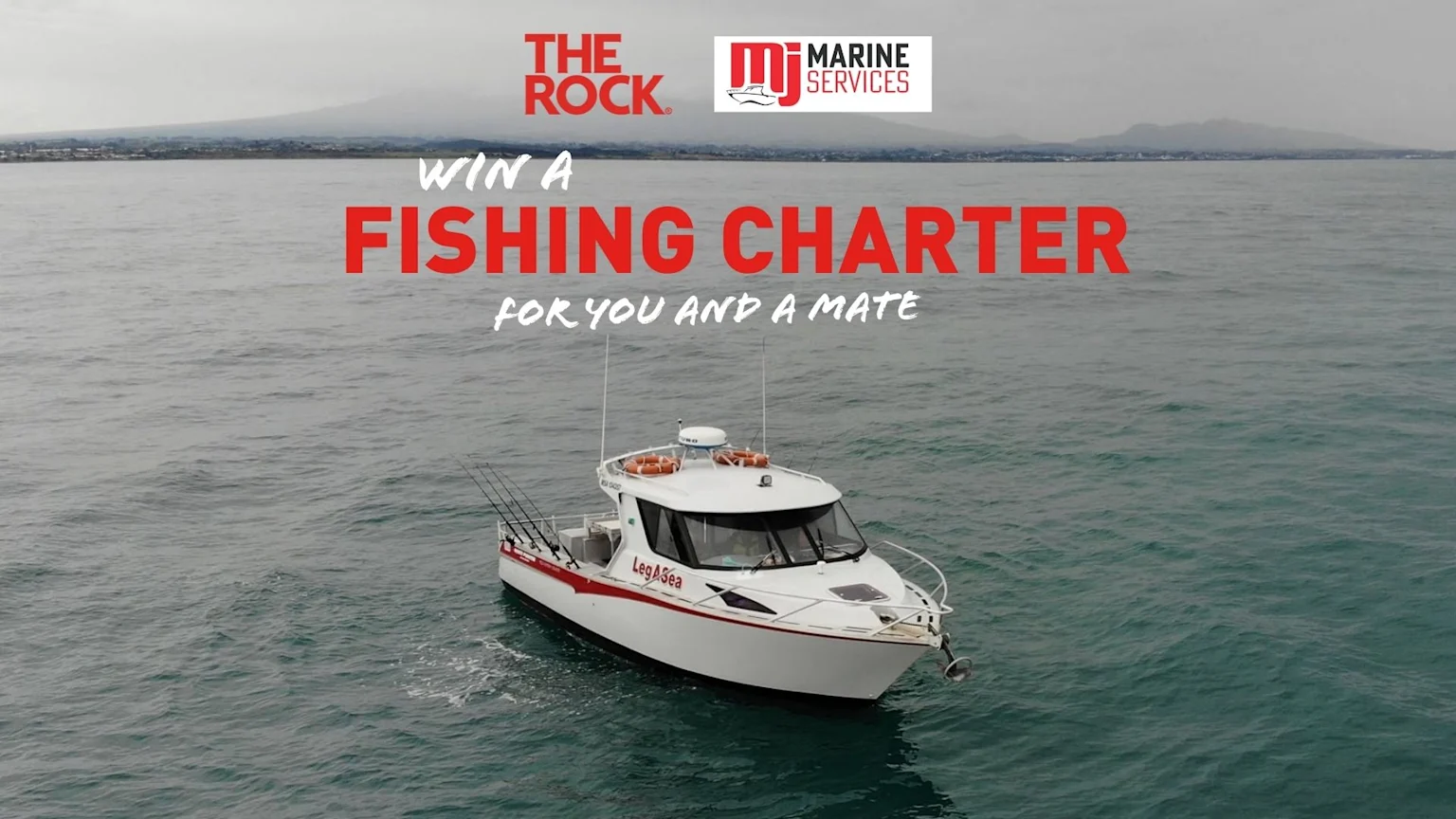 A white and red fishing boat named "LegASea" with fishing rods is on the water, with text "WIN A FISHING CHARTER FOR YOU AND A MATE" and logos for "THE ROCK." and "MJ MARINE SERVICES" at the top.