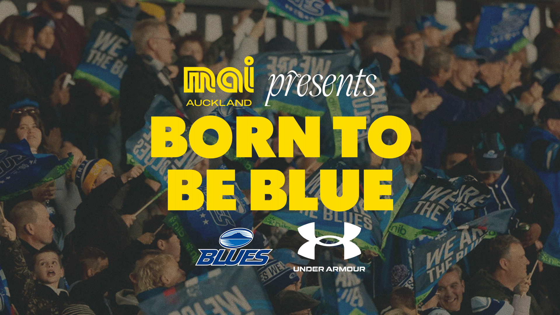 A cheering crowd of fans, many holding blue flags, beneath the text 'MAI AUCKLAND presents BORN TO BE BLUE' and logos for Mai, Blues, and Under Armour.