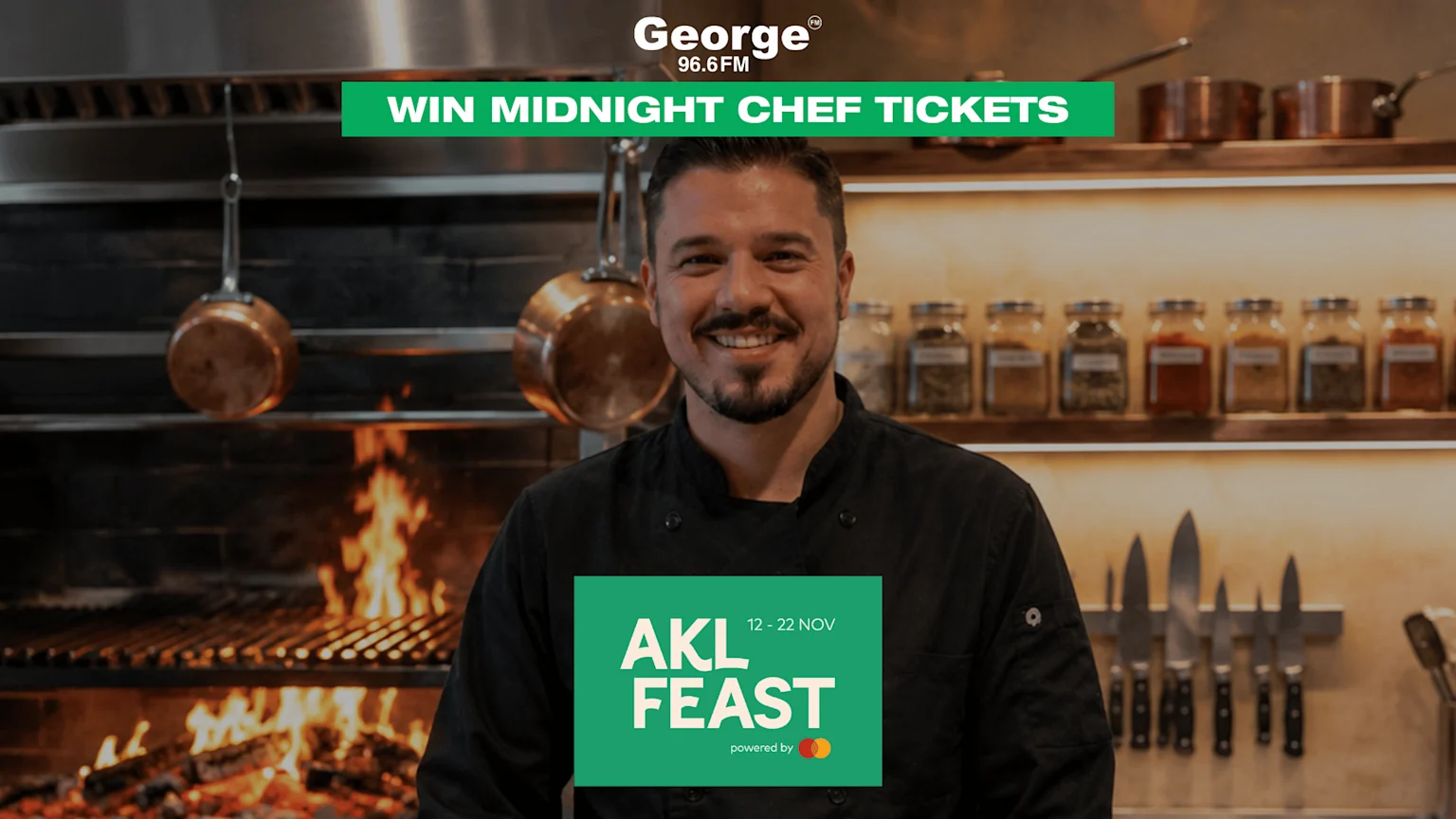 A smiling male chef in a black jacket is in a kitchen with a grill and flames, promoting "WIN MIDNIGHT CHEF TICKETS" by George 96.6FM and "AKL FEAST 12 - 22 NOV powered by Mastercard."