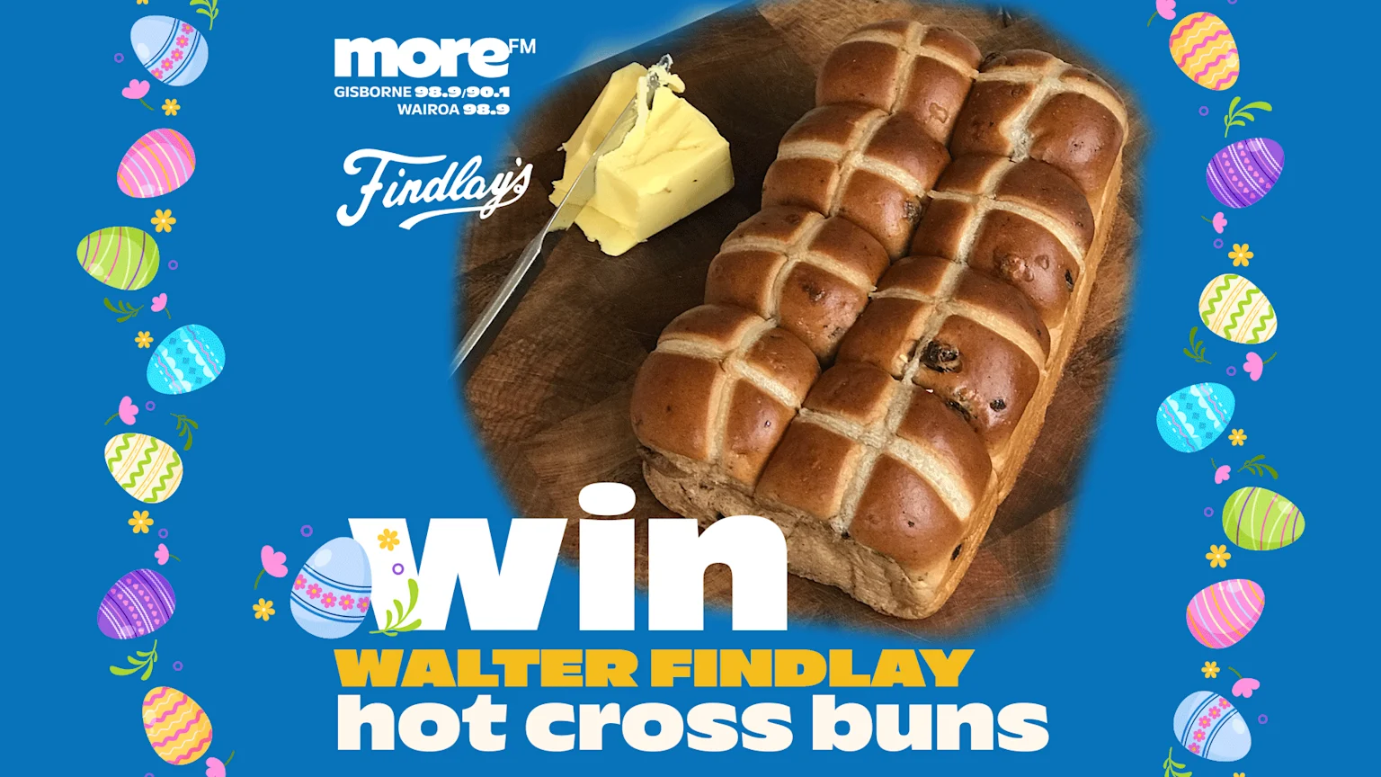 A blue background with Easter egg borders displays a loaf of Walter Findlay hot cross buns and butter on a wooden board, with text promoting a "Win Walter Findlay hot cross buns" contest from more FM.