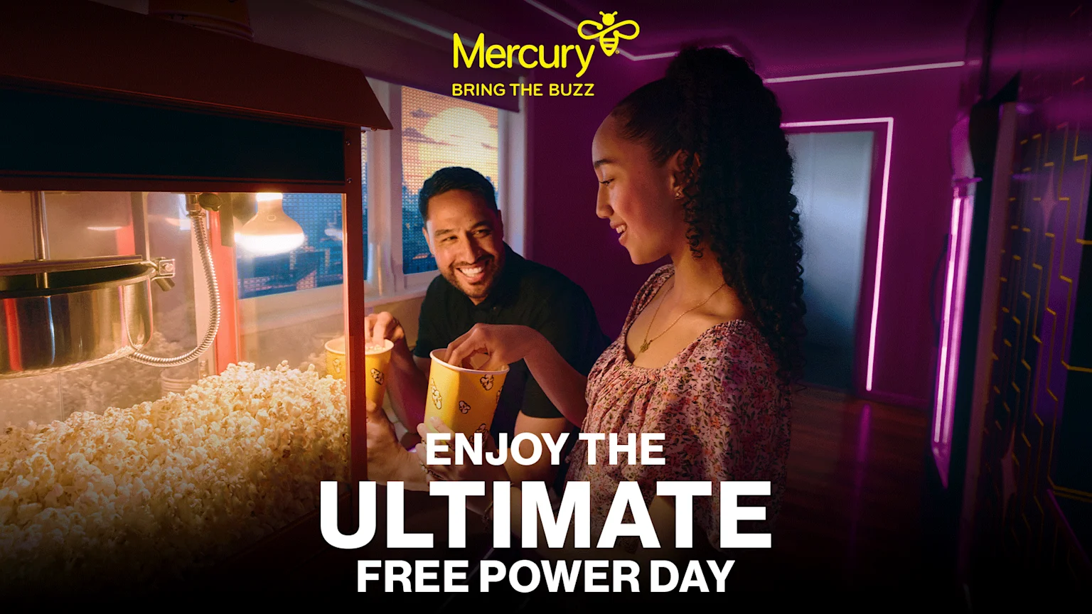 A smiling man and woman joyfully scoop popcorn from a machine in a vibrantly lit room, with the Mercury logo and "ENJOY THE ULTIMATE FREE POWER DAY" text.