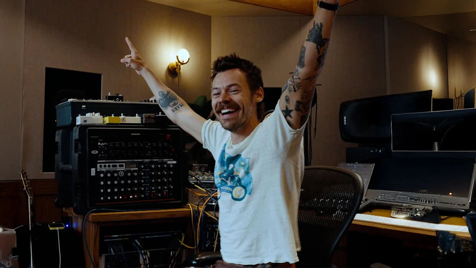 Excited musician with arms raised in studio