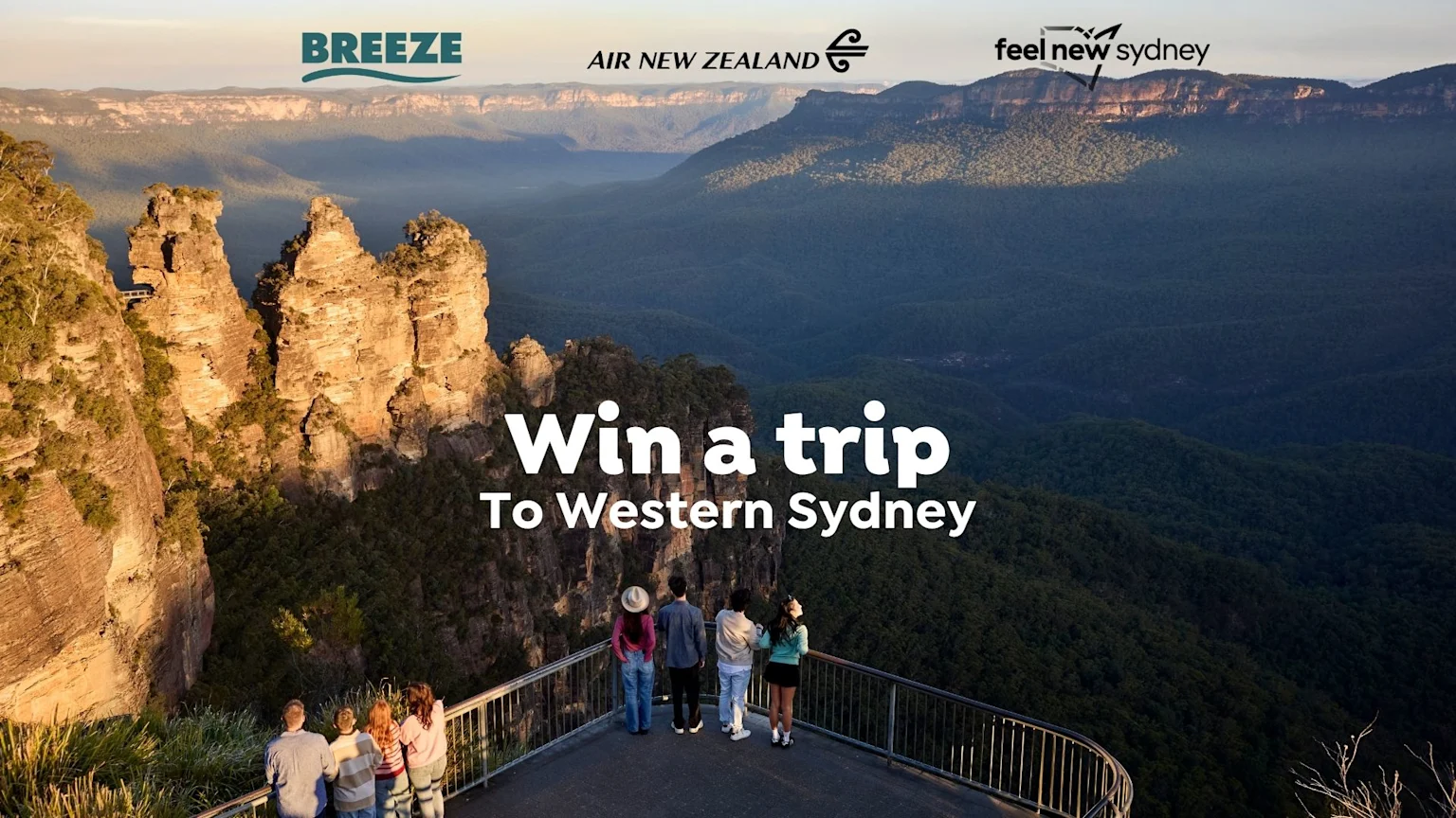 People on a lookout platform view the iconic Three Sisters rock formation of the Blue Mountains and forested valleys at sunset, with text "Win a trip To Western Sydney" and brand logos.