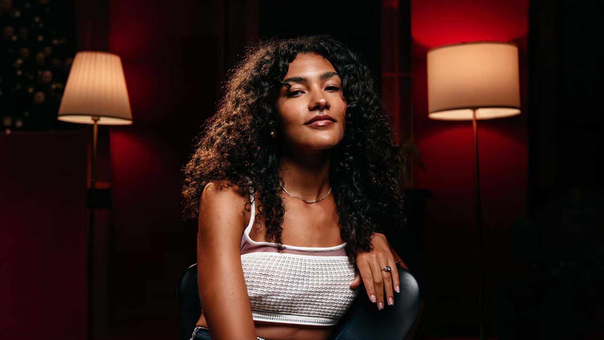 Person in white top in dimly lit room