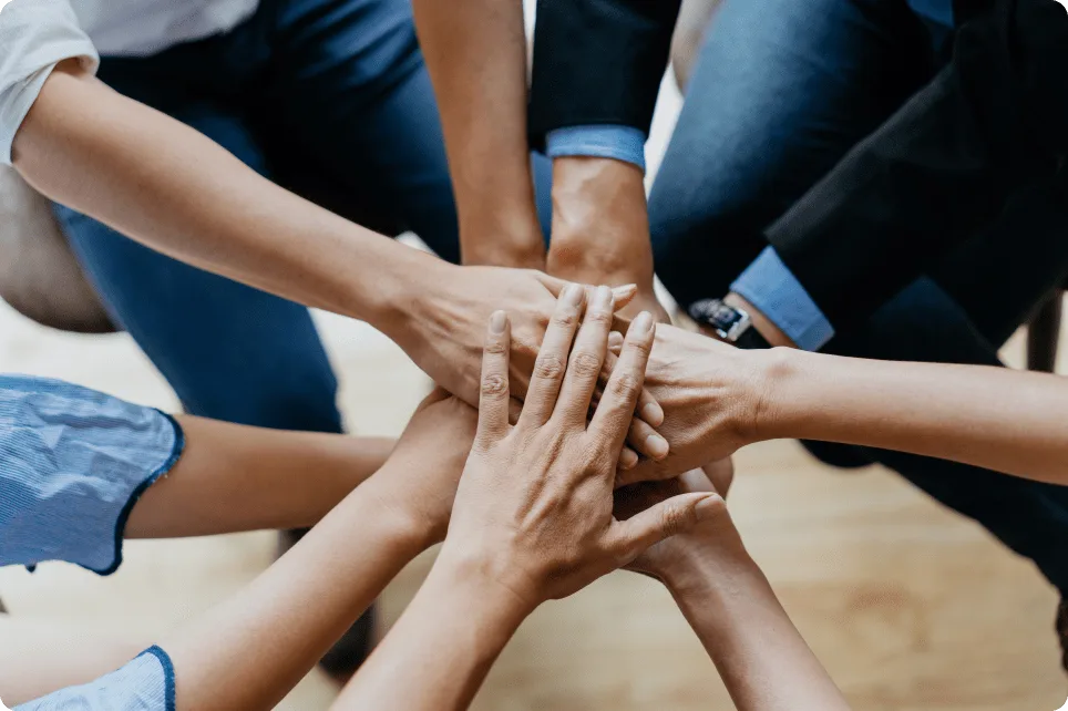 Photo of team with their hands in together