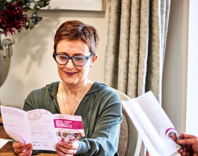 Person with glasses reading a Join Dementia Research pamphlet