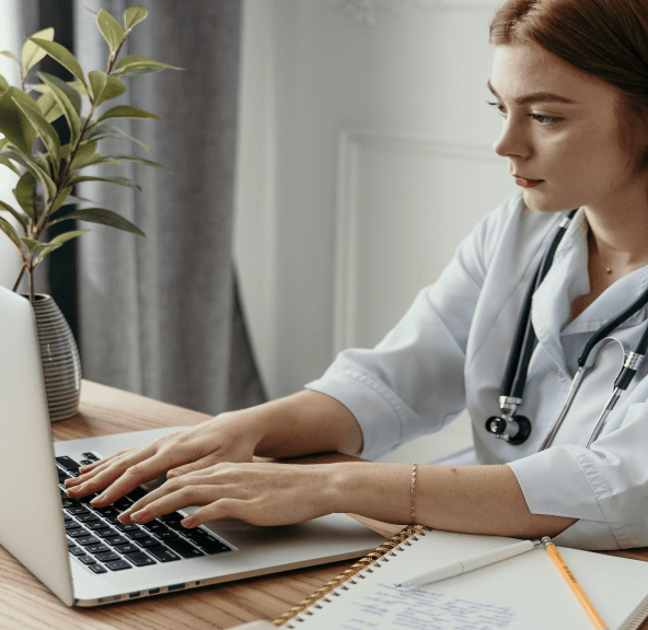 A healthcare professional working on a laptop