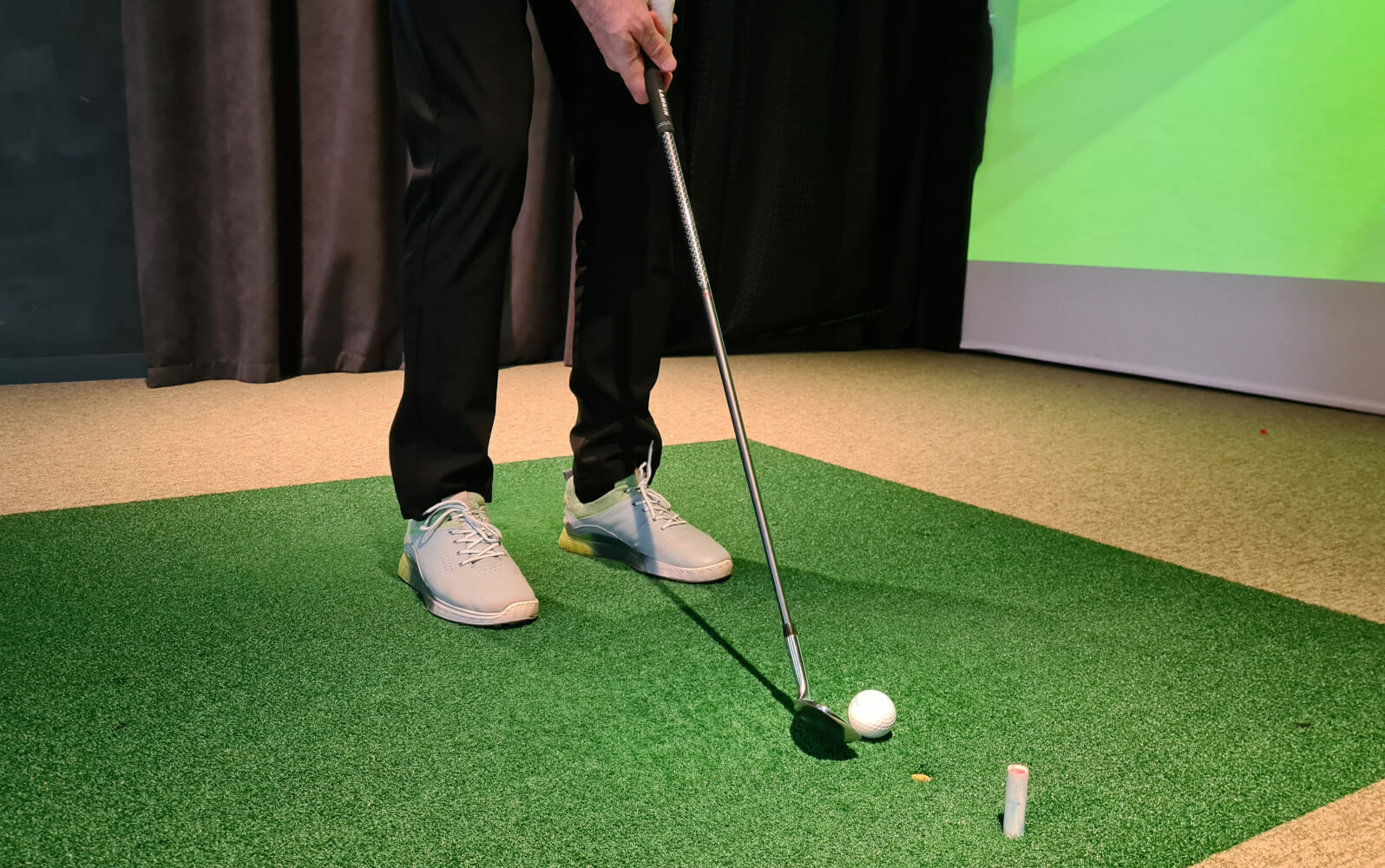 A person putting a golf ball