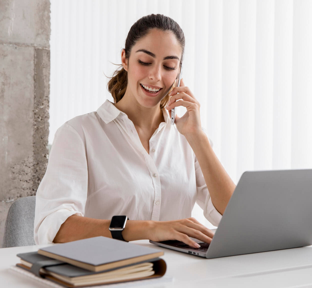 A woman using a mobile device and computer