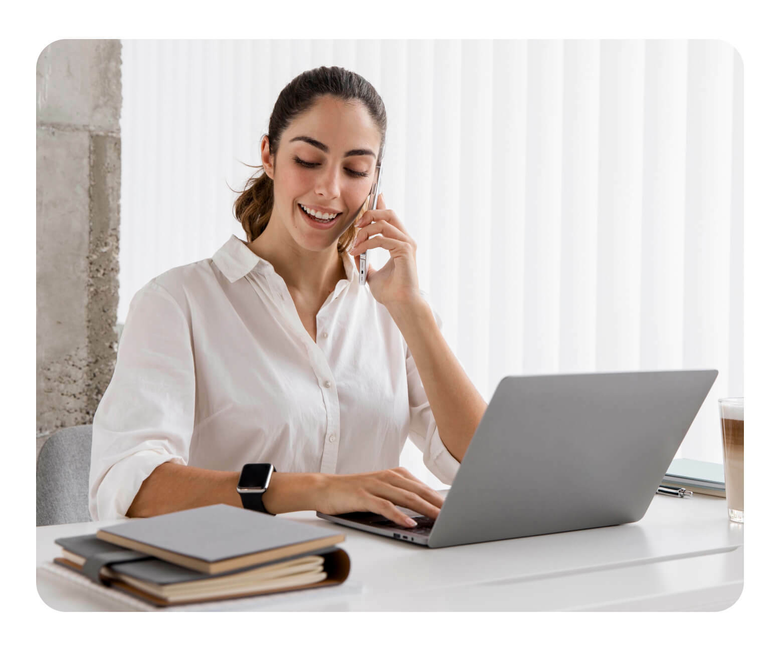 A woman using a mobile device and computer