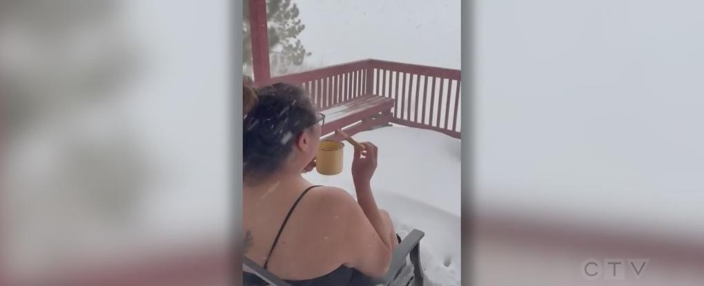 Woman having breakfast outside during snow storm