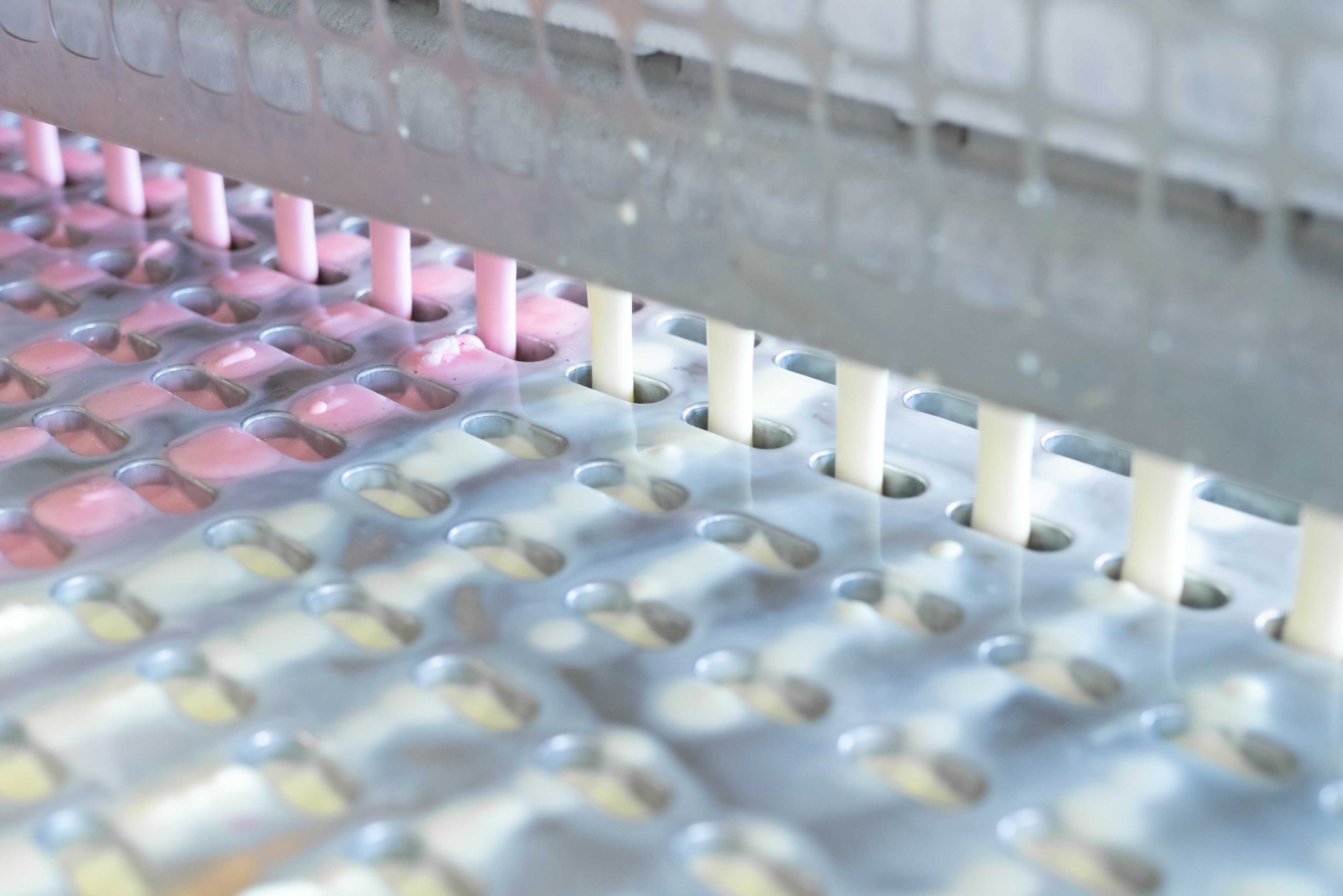 Glace-Mix läuft über Rohre in die Formen