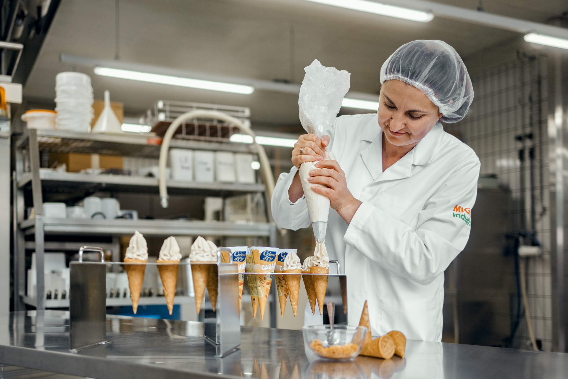 Biljana Stamenkova riempie le farciture per gelato nei cornetti da Delica