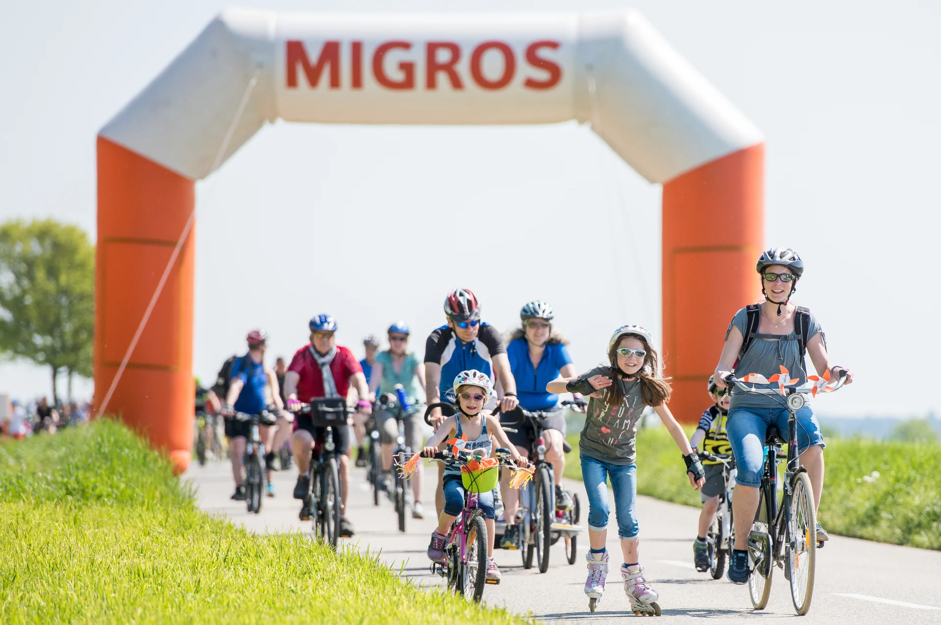 Familien auf dem Velo und mit Inline-Skates fahren auf der Landstrasse.