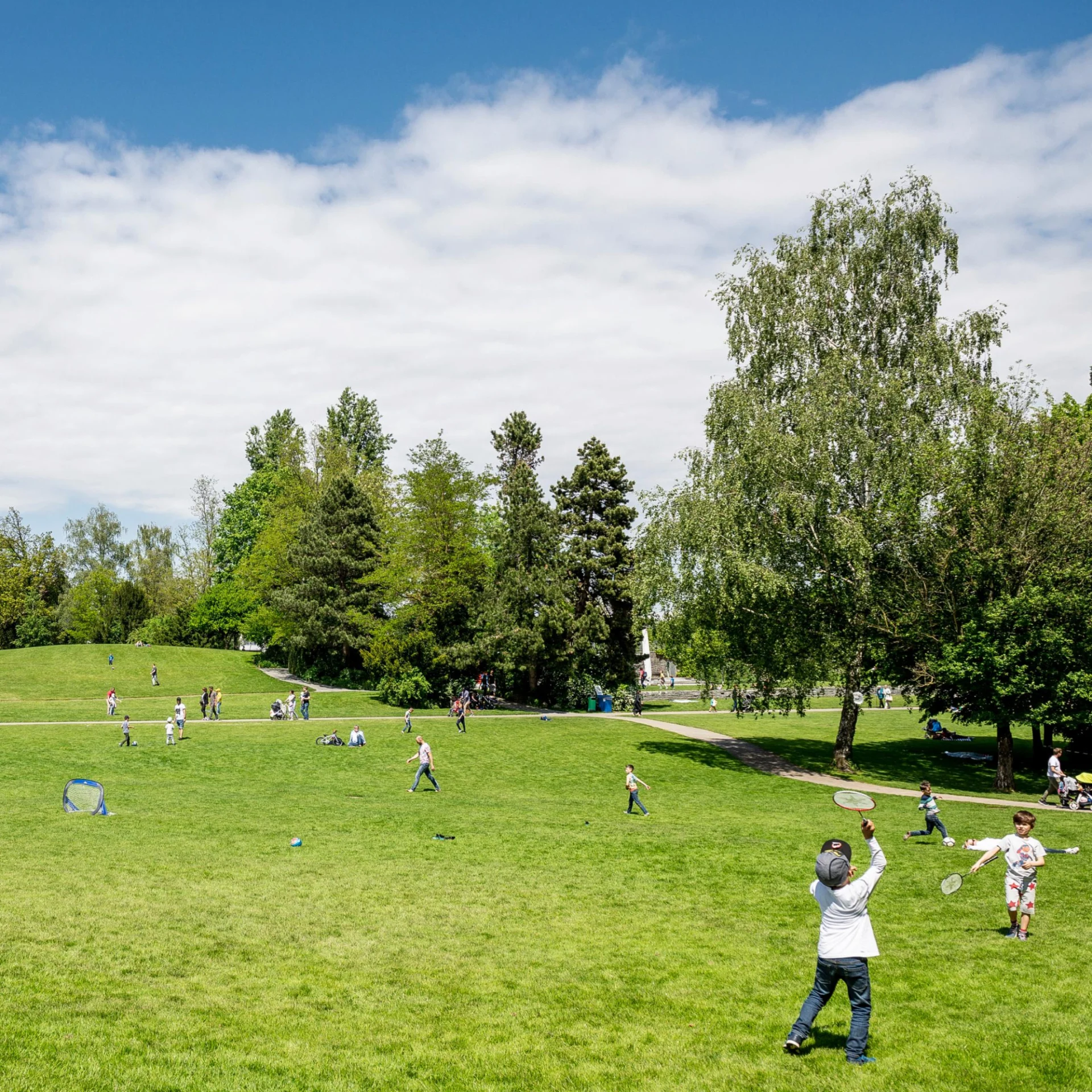 Kinder spielen auf einer Wiese in einem Park