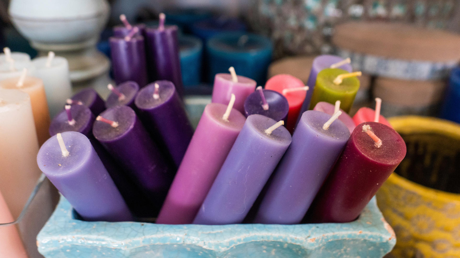 Coloured candles in a ceramic holder