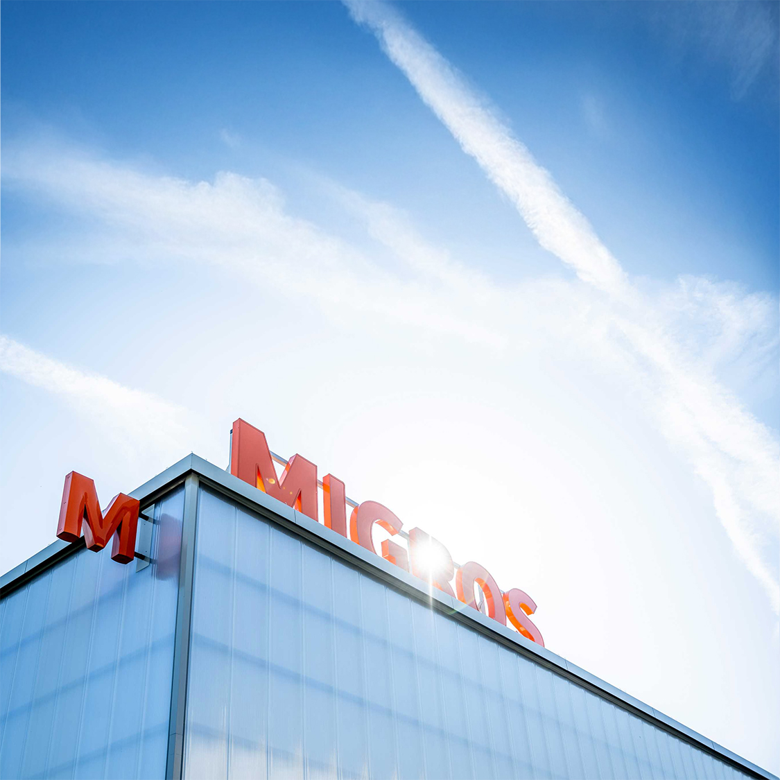 Scritta Migros su un edificio di vetro