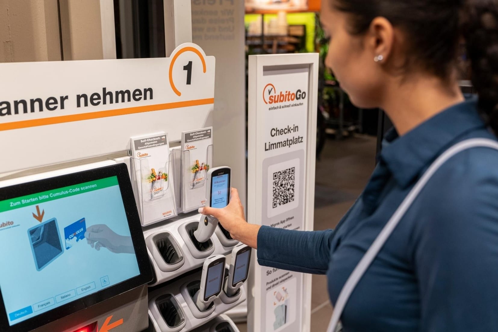 Eine Frau nimmt sich einen Handscanner aus der Halterung