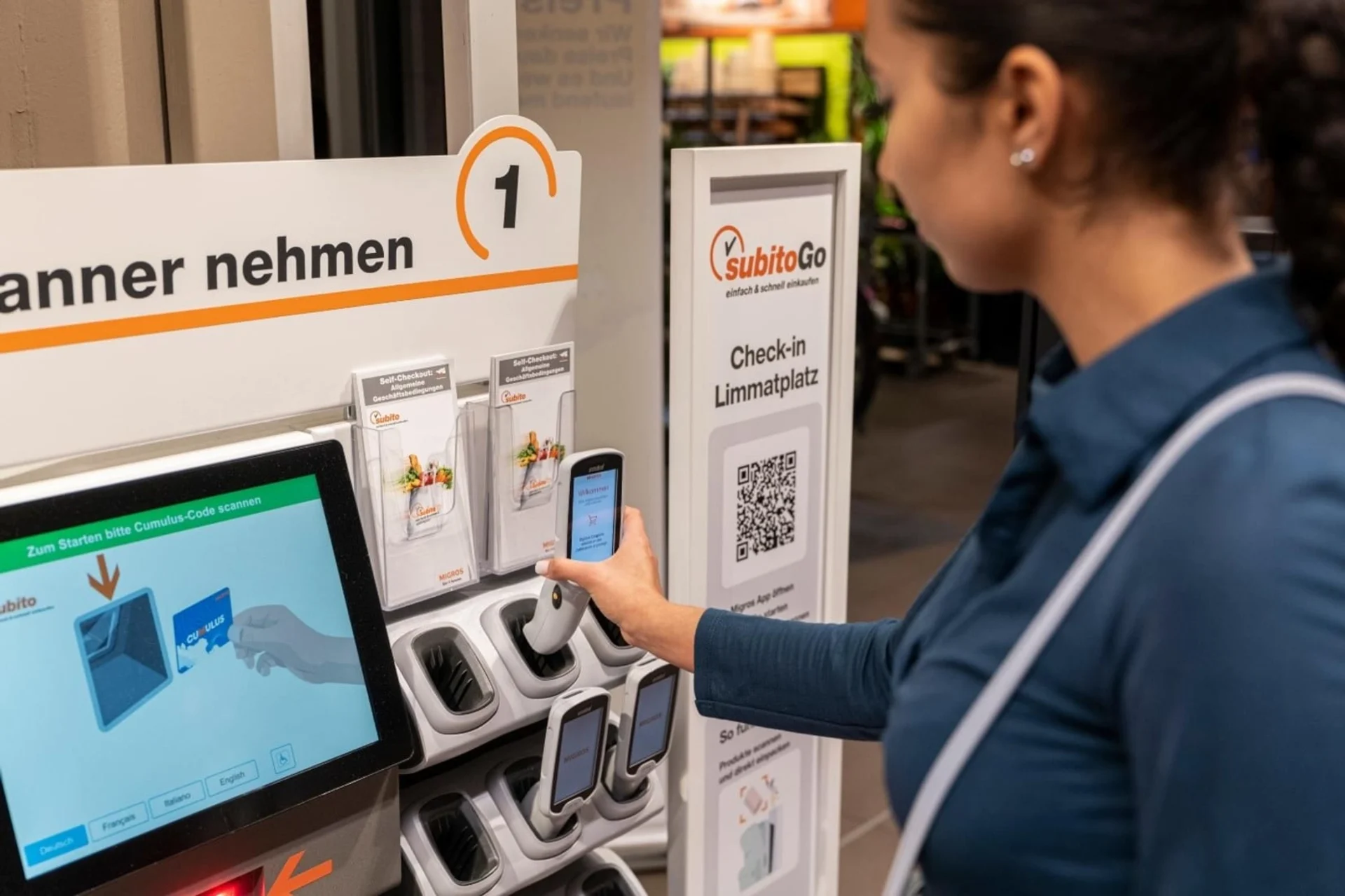 Eine Frau nimmt sich einen Handscanner aus der Halterung